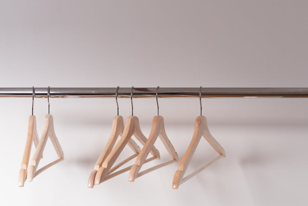 wooden-clothes-hangers-cling-emptily-to-the-shiny-shop-rack